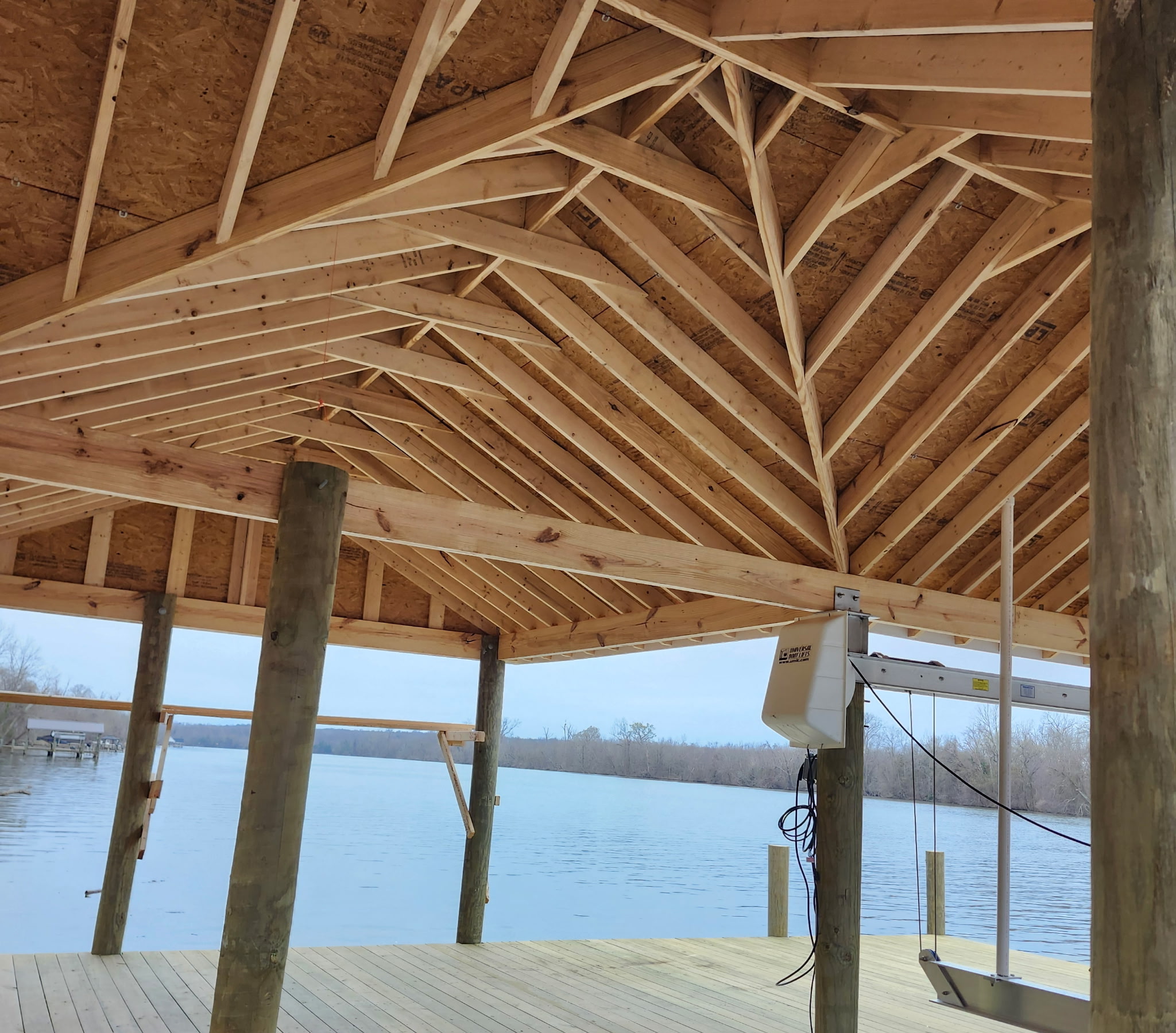 Close view of timber roof framing over a waterfront dock