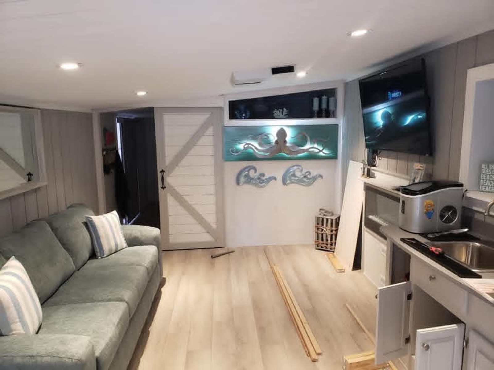Finished room with white barn doors, wood trim, and kitchenette