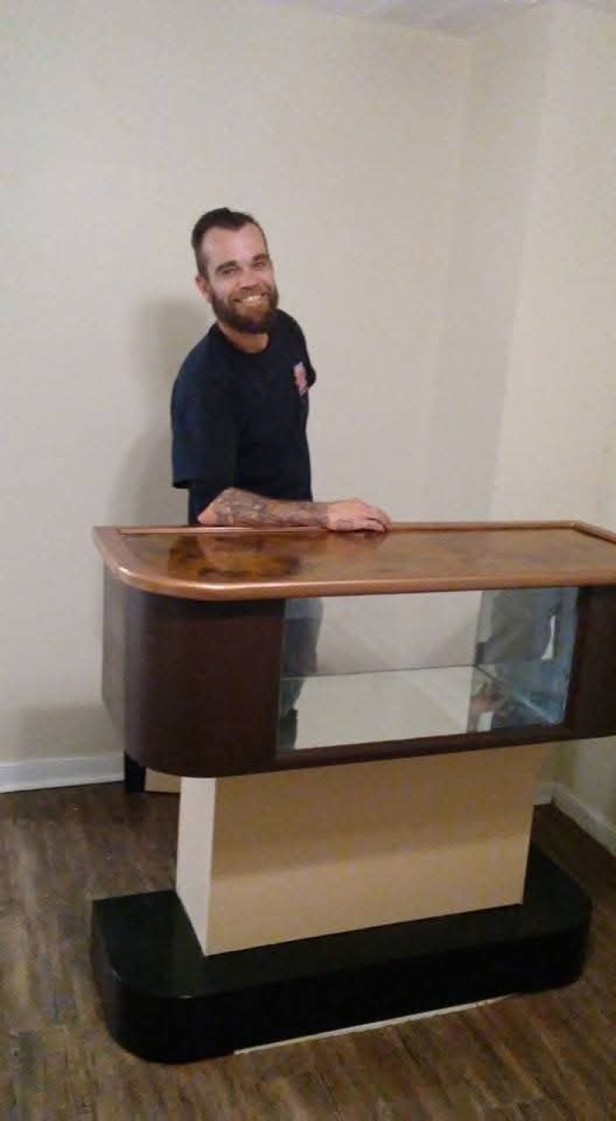J.D. Adams standing behind a custom curved wood bar