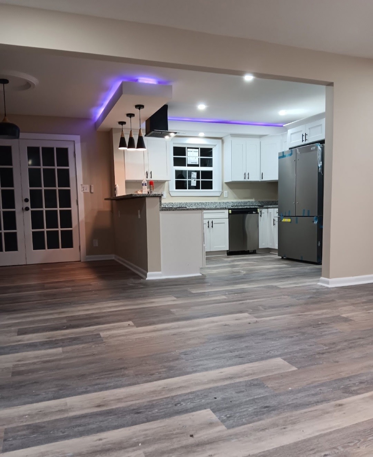 Finished open-plan kitchen with white cabinetry and dark counters