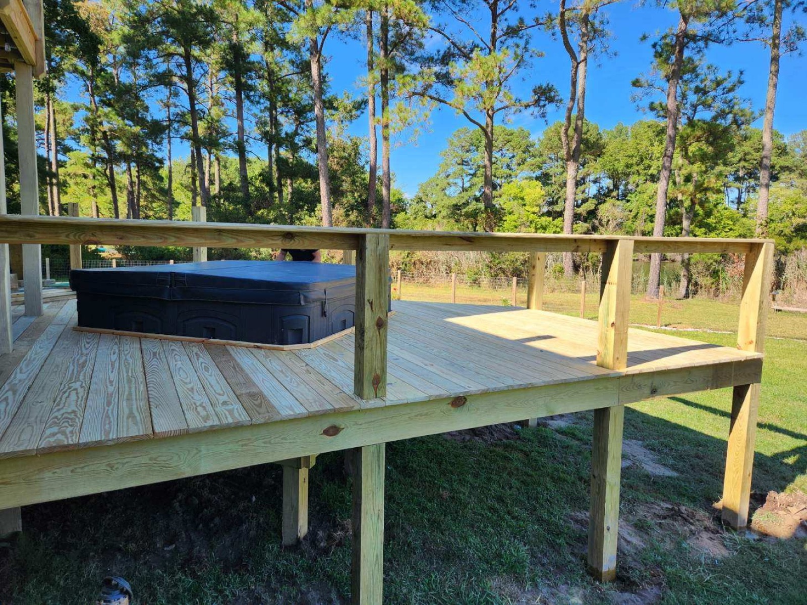 Raised timber deck with railing built around a hot tub